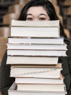 Korean student holding stack of books