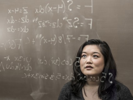 Korean student looking at formula on glass wall