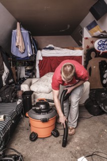 Caucasian man vacuuming floor