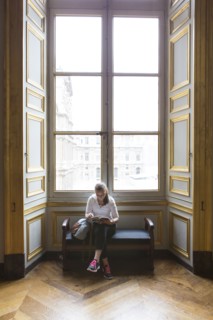 Caucasian teenage girl studying in ornate window at Louvre Museum