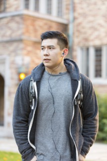 Mixed race college student listening to music on headphones