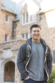 Mixed race college student listening to music on headphones