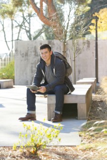 Mixed race college student using digital tablet on campus