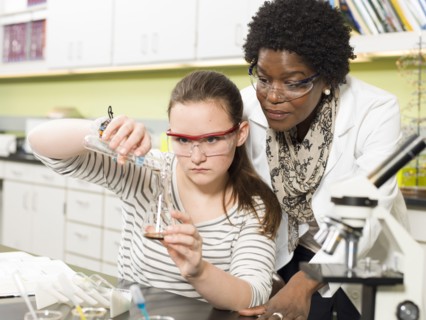 Student and teacher working in chemistry lab