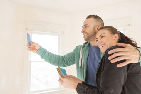 Mixed race couple selecting color swatches in new home