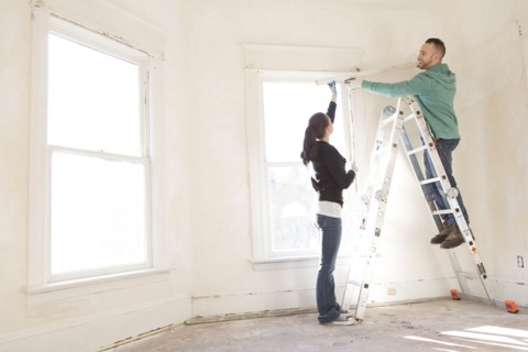 Mixed race couple installing shade in new home
