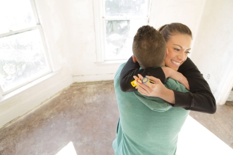 Mixed race couple hugging in new home