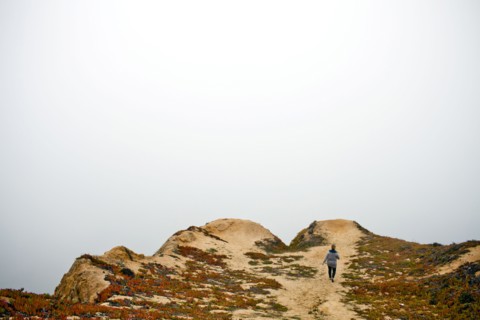 Caucasian woman walking on sand dunes