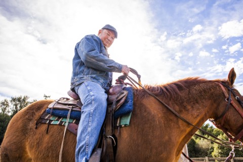 Caucasian rancher riding horse outdoors