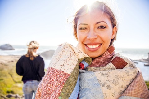 Woman wrapped in blanket on rural hillside