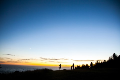 Silhouette of family on rural hillside at sunset