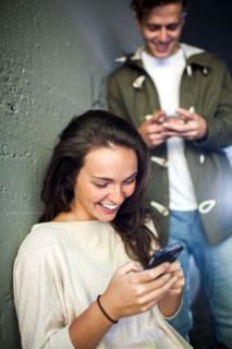 Caucasian couple using cell phones together in tunnel