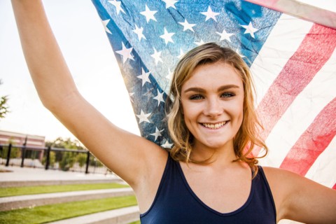 Caucasian teenage girl holding American flag