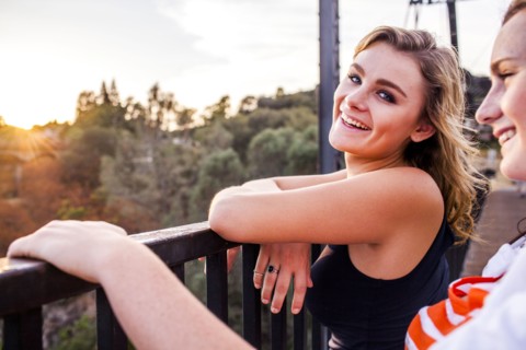 Caucasian teenage girls standing on bridge