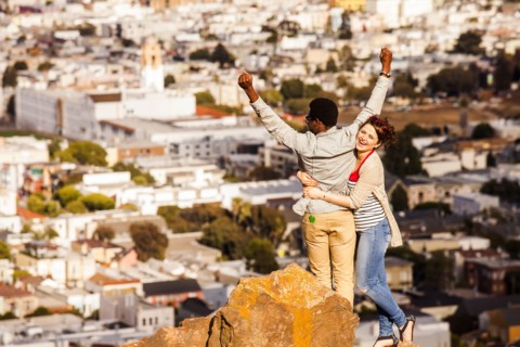 Couple cheering near scenic view of cityscape