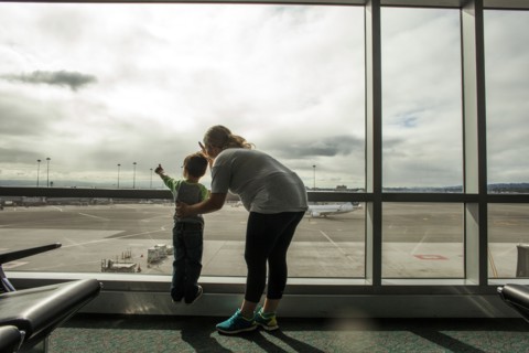Mother and son looking out airport window
