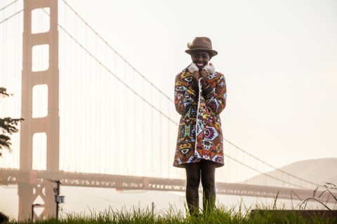 Black woman wearing colorful coat by Golden Gate Bridge