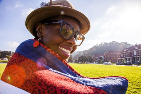 Black woman wrapped in blanket in urban park