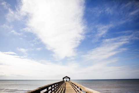 Wooden pier under blue sky over ocean