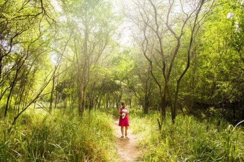Caucasian woman carrying baby in lush jungle