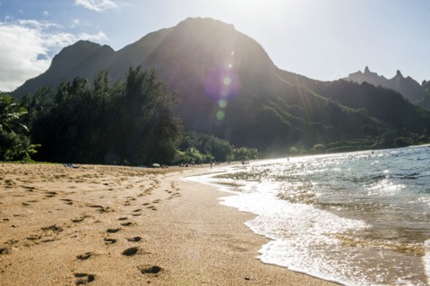 Footprints on sand near waves on tropical beach