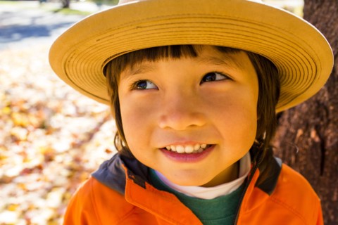 Close up of smiling mixed race boy wearing sun hat