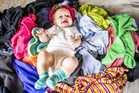 Caucasian baby girl laying in pile of laundry