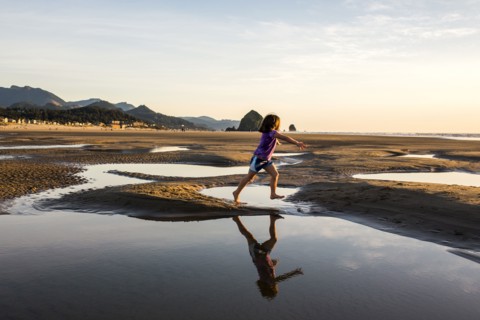 Caucasian girl running in tide pools on beach