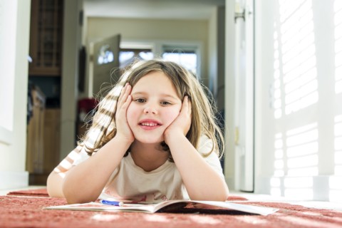 Close up of Caucasian girl reading book on floor