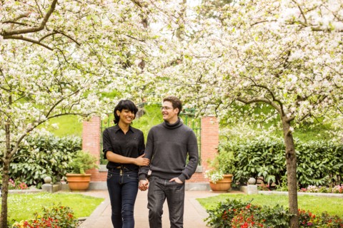 Couple walking under flowering trees in park