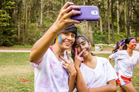 Friends taking selfie covered in pigment powder