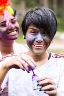Smiling friends covered in pigment powder