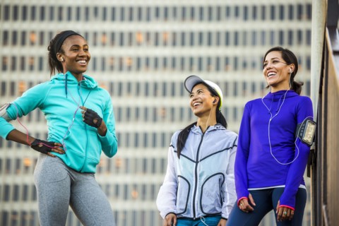 Runners laughing near highrise building