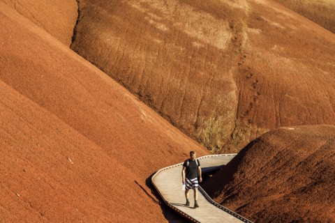 Caucasian hiker on wooden walkway in desert hills