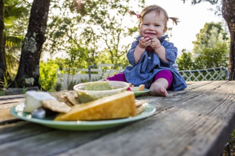 Caucasian baby girl sitting on patio table