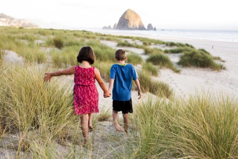 Caucasian children walking on beach