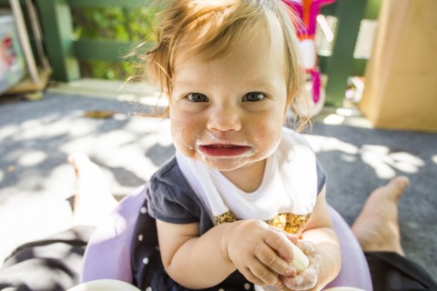Caucasian baby girl eating on patio