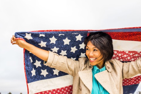 Woman holding American flag quilt outdoors