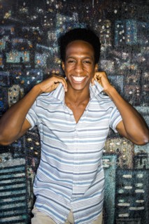 Man lifting his collar by mural