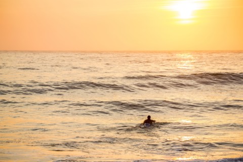 Caucasian surfer swimming in waves
