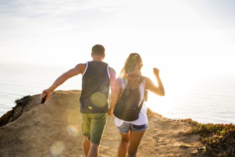 Caucasian couple walking on cliff