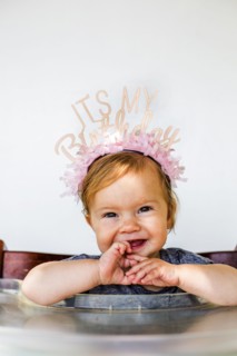 Caucasian baby girl wearing birthday crown