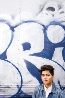 Asian woman standing at graffiti wall
