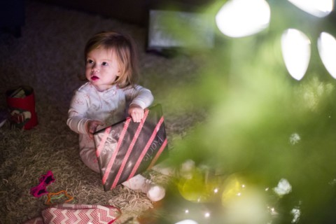 Caucasian girl opening Christmas gift