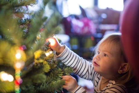 Caucasian girl decorating Christmas tree