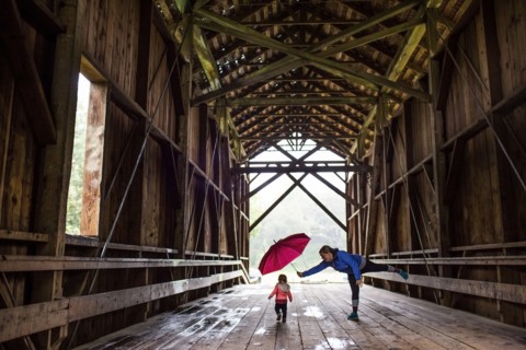 Caucasian mother and baby daughter on covered bridge