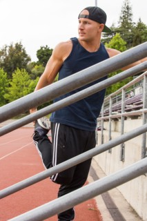 Caucasian man stretching leg at running track