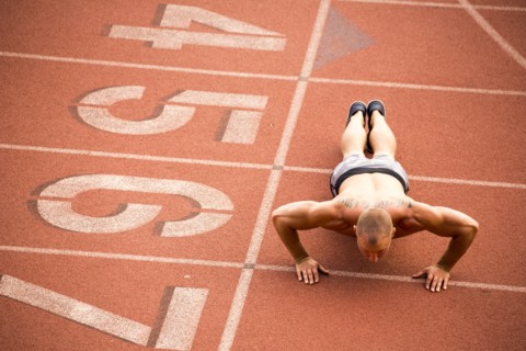 Caucasian man doing push-ups on running track