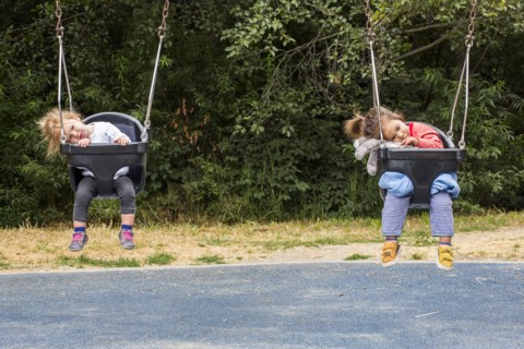 Girls sitting in still swings