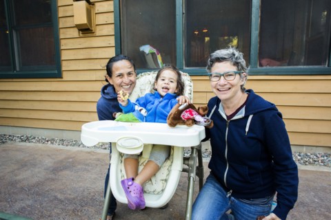 Mothers posing with daughter in high chair
